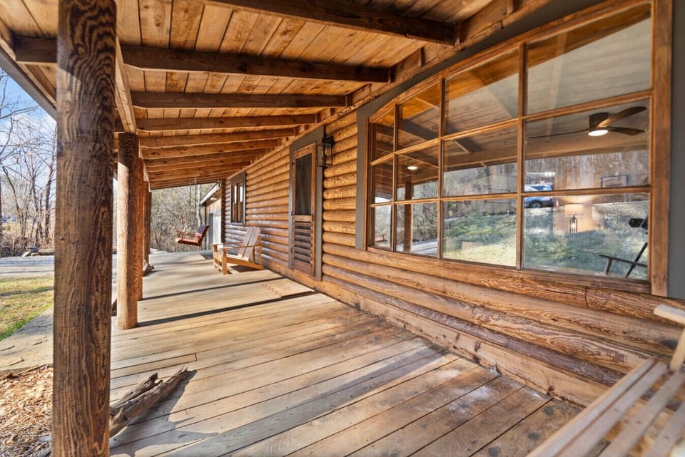 Rustic charm meets relaxation – unwind on this cozy cedar cabin porch, surrounded by nature and timeless craftsmanship.