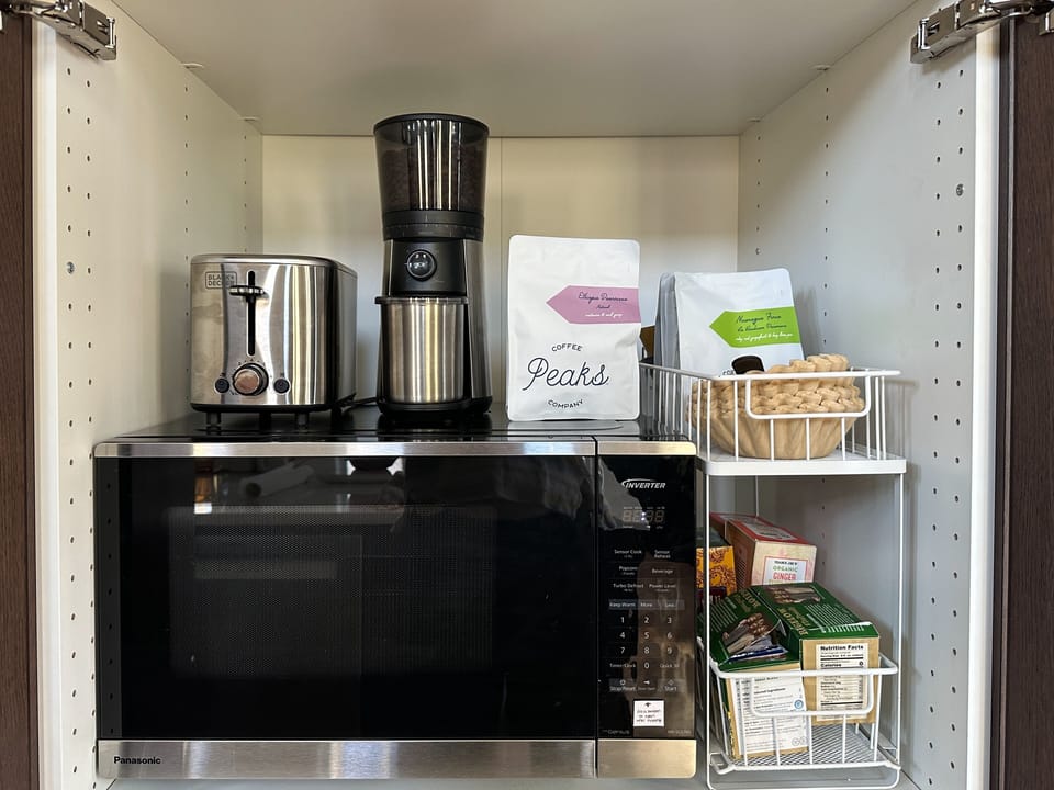 pantry stocked with toaster, coffee grinder, microwave, and more