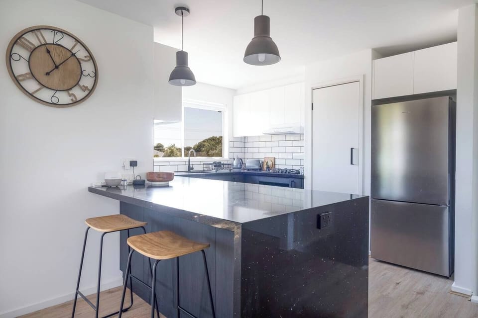 The breakfast bar with stools offers a perfect spot for casual bites and conversation.
