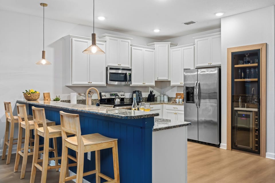 Stylish kitchen with modern appliances, breakfast bar, and dining area

