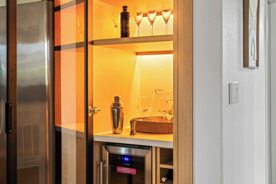 Stylish Orlando home bar with wine fridge, cocktails, and warm lighting—perfect.