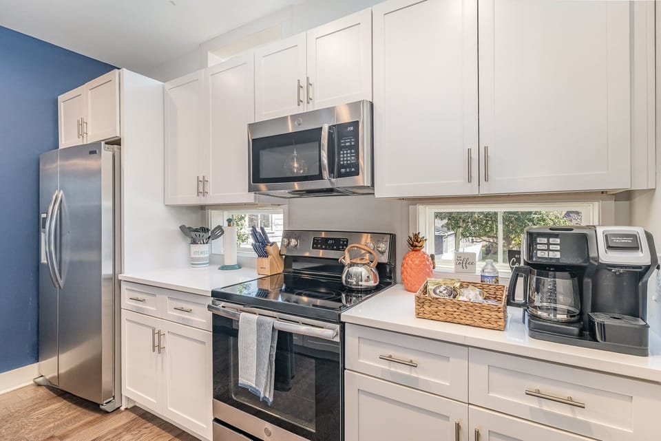 The fully equipped modern kitchen features culinary essentials, stainless steel appliances, and island bar seating. (2nd Floor)