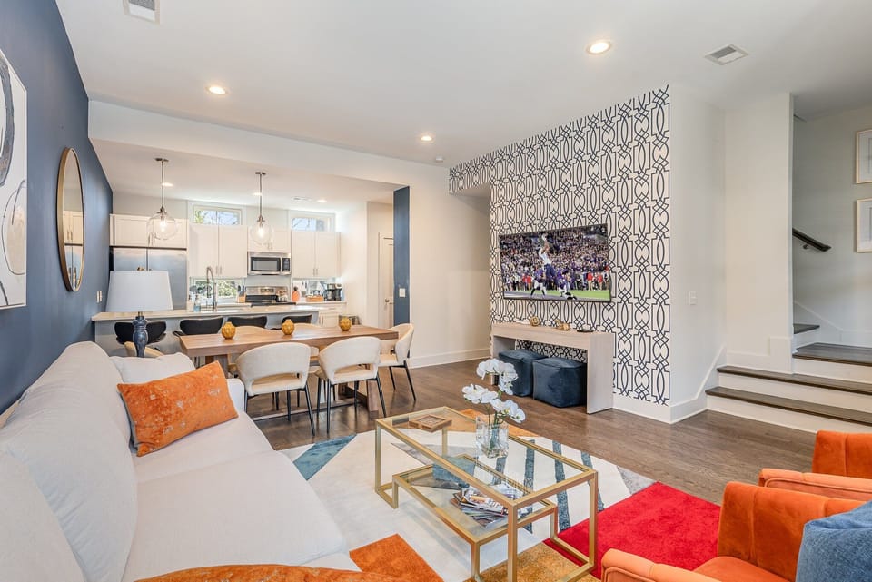 Bright open floor living space featuring a smart flat-screen TV, comfortable furnishings, and access to the outdoor patio. (2nd Floor)