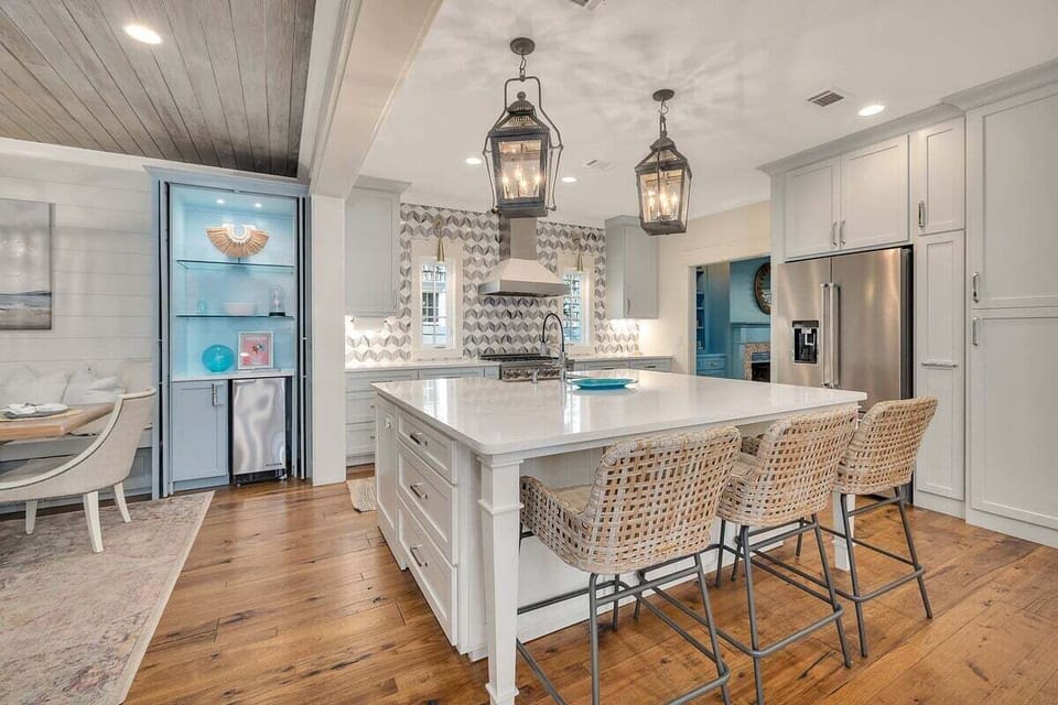 Kitchen island with rattan stools and lantern pendants