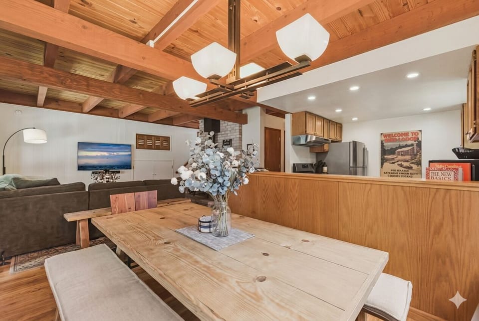 Open dining area with wood accents flowing into kitchen and living room.

