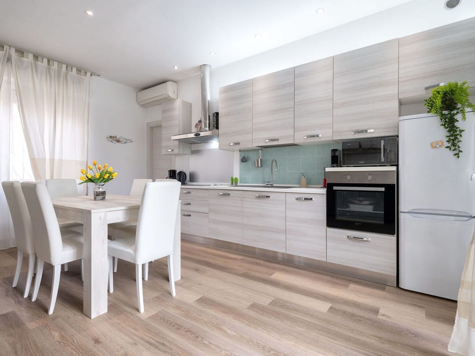 Furniture, Kitchen, Kitchen Appliance, Interior Design, Flooring, Countertop, Cabinetry, Floor, Major Appliance, Wood