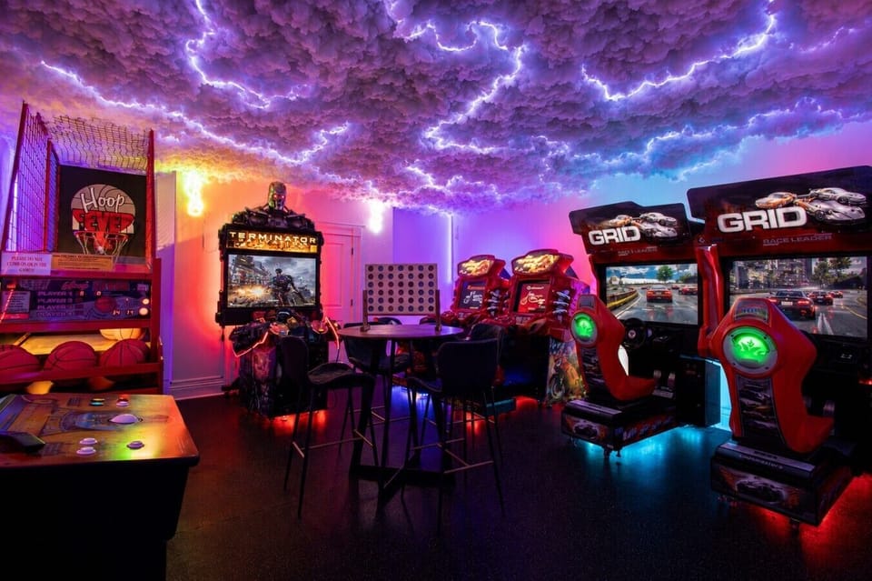 The private arcade features linked racing simulators, basketball, PlayStation 5, Golden Tee and classic games.