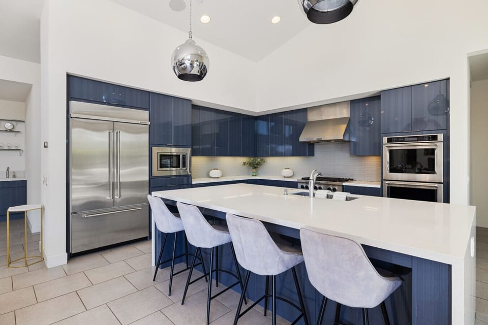 Sleek kitchen w/ large island, bar stools & modern cabinetry for easy gatherings