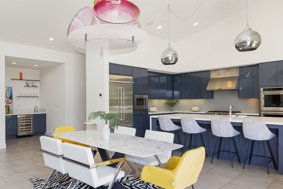Sleek kitchen w/ long island, bar seating & pendant lighting for casual gatherings