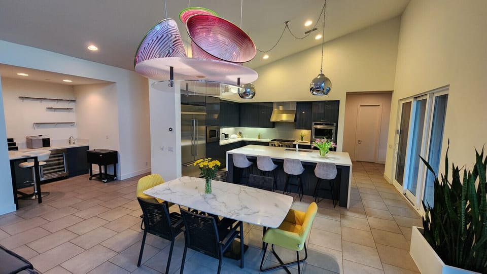 Modern dining area w/ statement lighting & open flow into the kitchen space