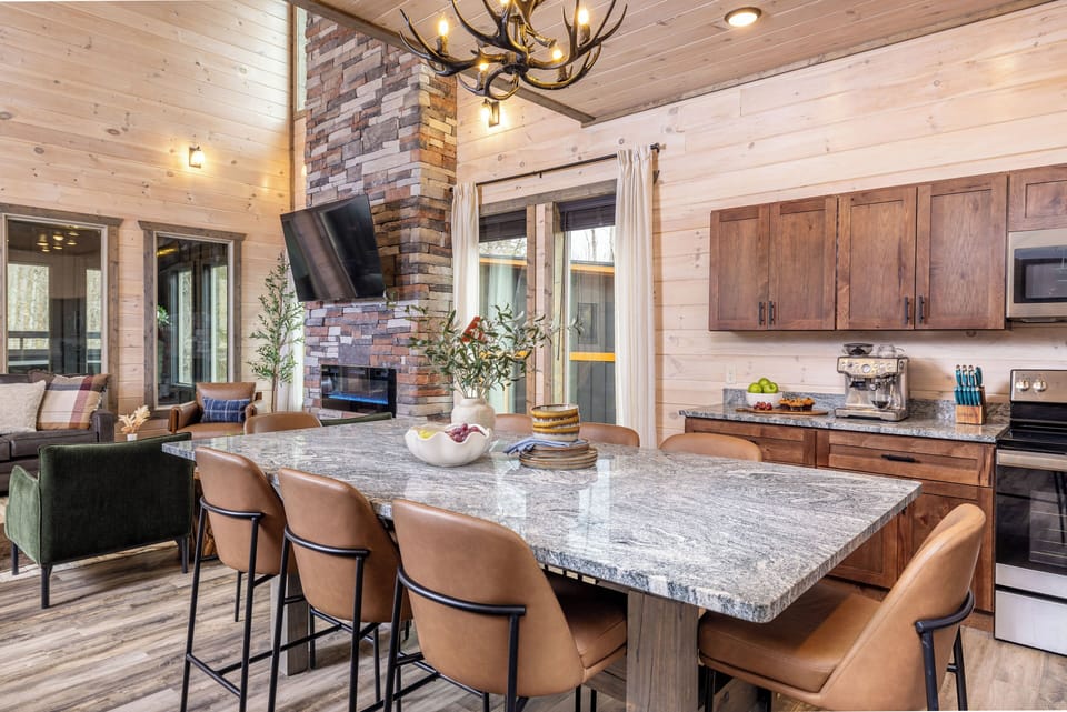 Modern kitchen with island seating, fireplace views & full cooking essentials