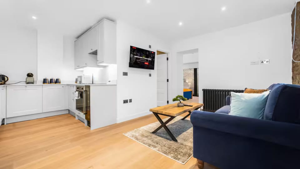 Cozy living area with sofa bed, TV, Netflix, and sleek table for relaxing.