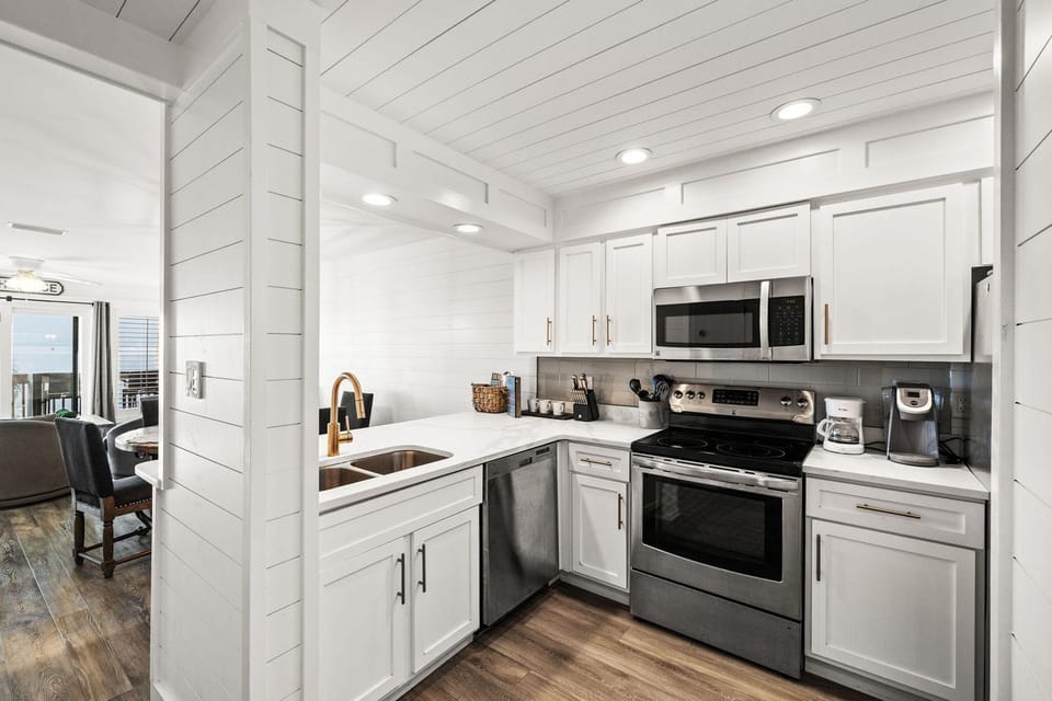 Your bright white kitchen features stainless steel appliances and warm wood floors, perfect for preparing meals during your stay.
