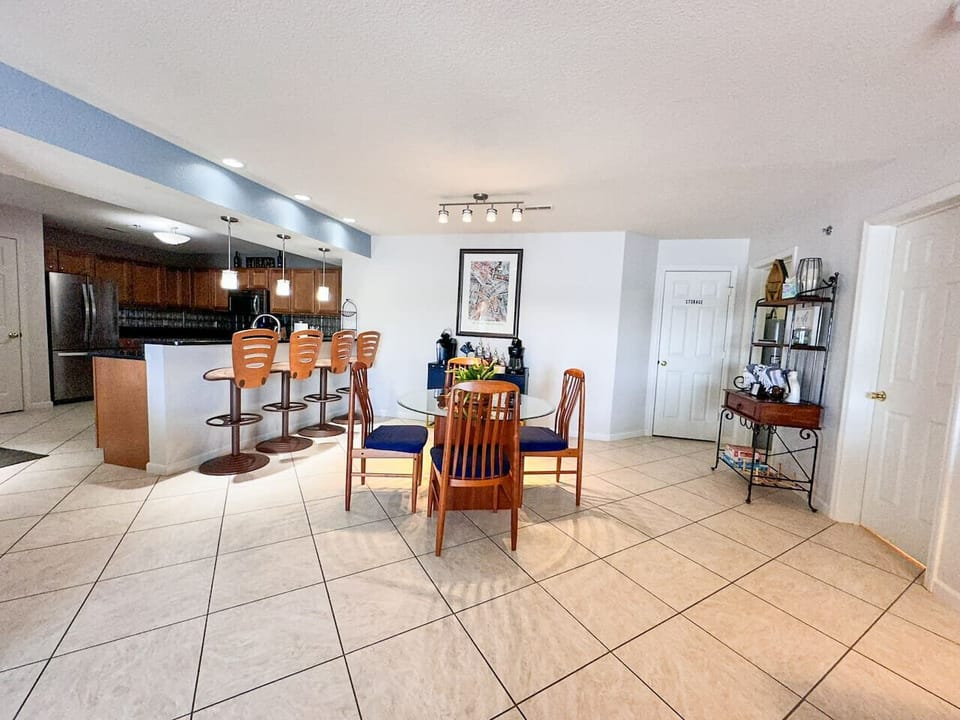 A fully equipped modern kitchen with stainless steel appliances, bar seating, and a large dining area—perfect for cooking and entertaining.