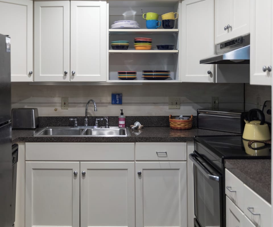 Small kitchen with all the essentials including a stove and full fridge