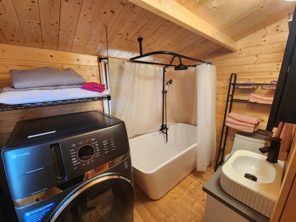 Full bathroom with tub/shower combo and two in one washer/dryer
