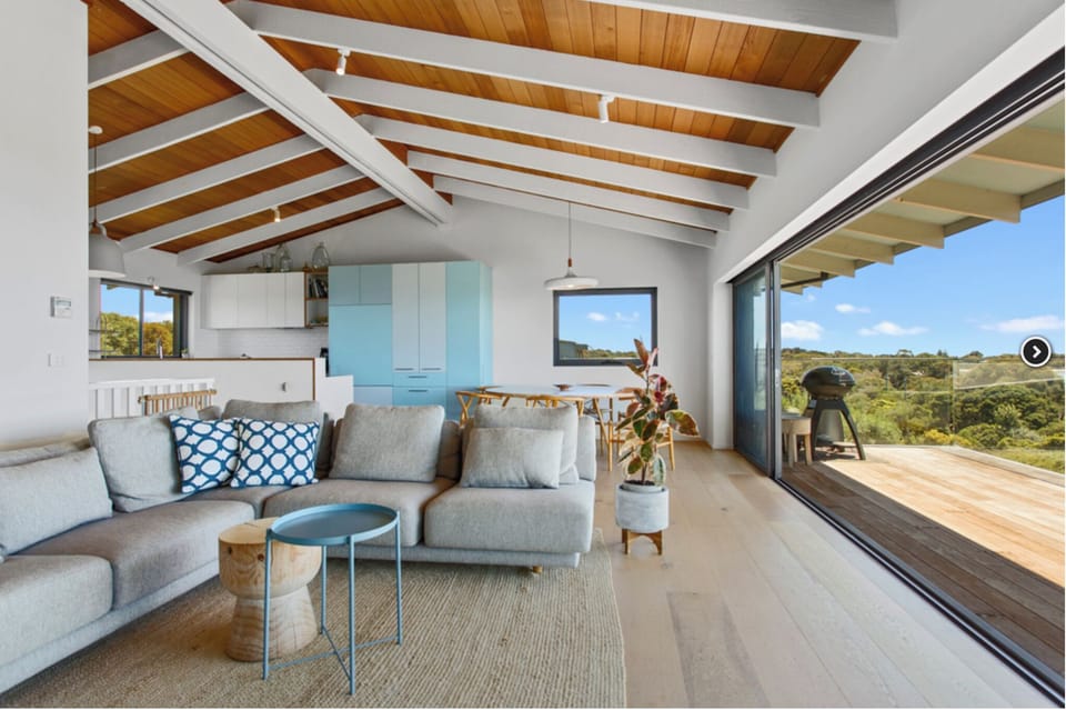 Bright open lounge, dining & kitchen with sliding doors onto expansive deck