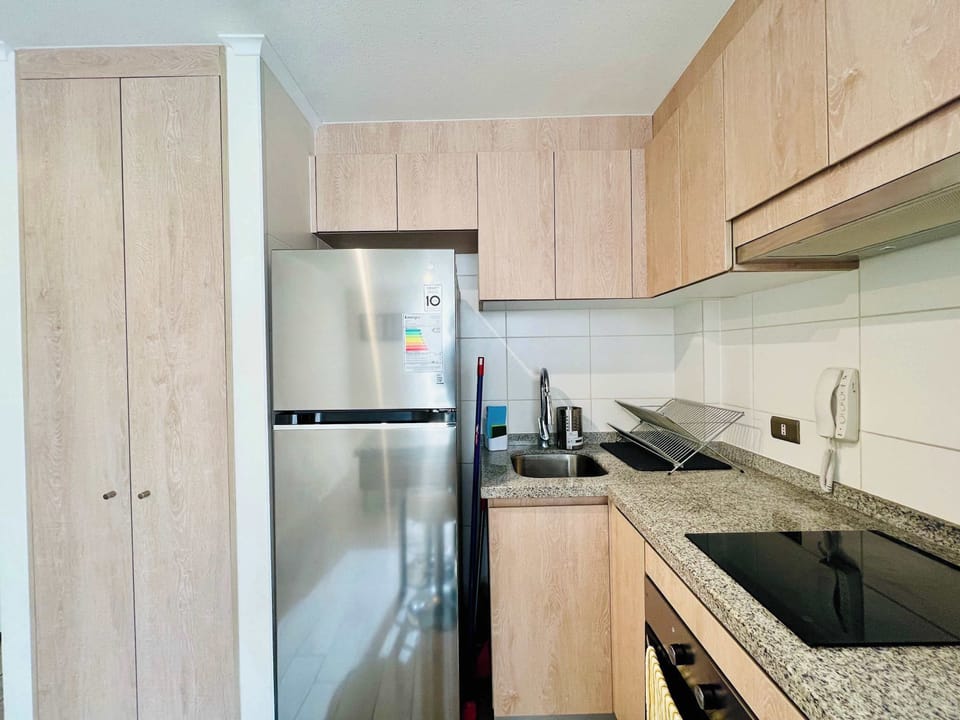 Compact kitchen w/ full-size fridge, stove & plenty of cabinet storage.
