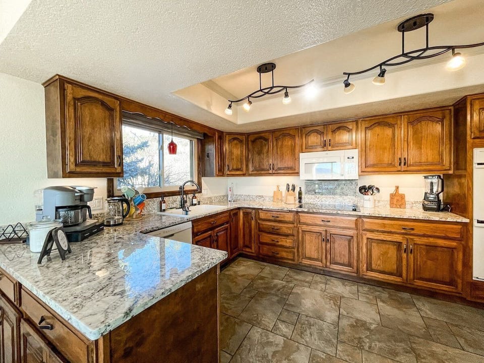 The fully-equipped kitchen features granite countertops, stainless steel appliances and ample space to prepare group meals.