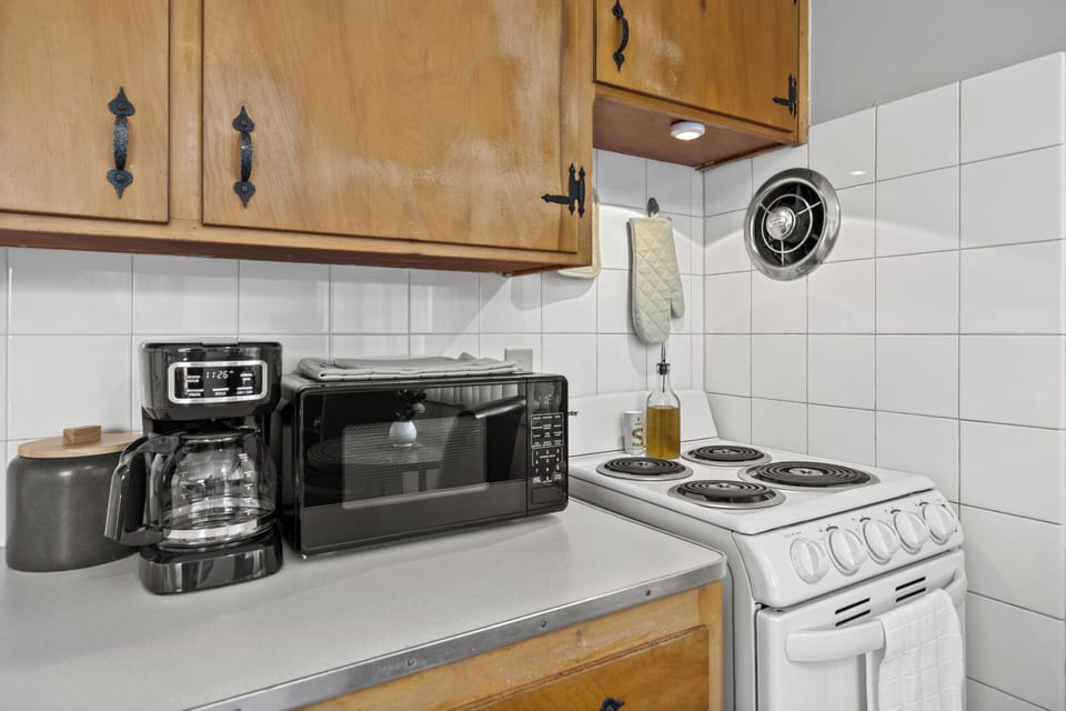 Fully stocked kitchen with coffee, tea, utensils, toaster, microwave, and more.