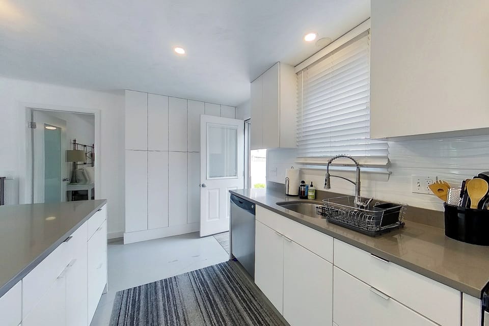 🍽️ Bright and modern kitchen with stainless steel appliances and Ceaserstone® Countertops. 