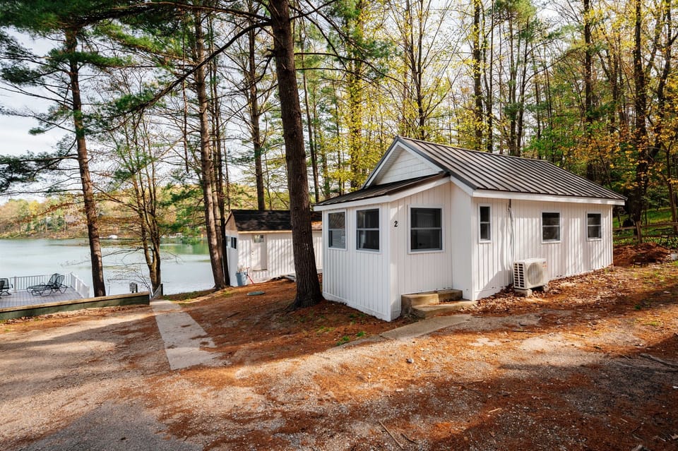 Charming Cabin: Enjoy peaceful summer lake views framed by towering green pines — the perfect setting for sunny lake days, warm evening breezes, and relaxing seasonal escapes ☀️🌲🌊