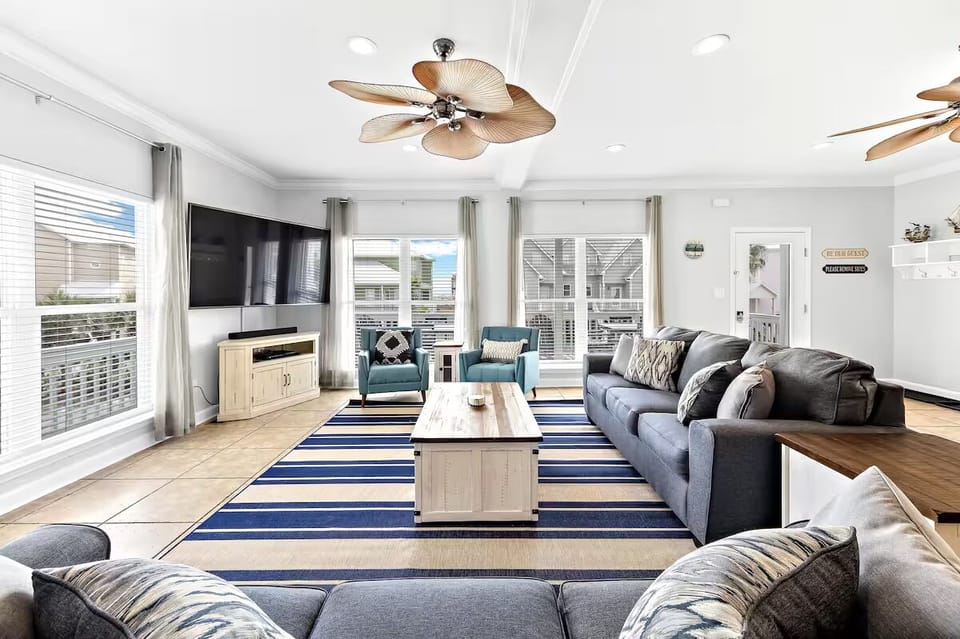 Bright, stylish living room with cozy seating, smart TV, and a cozy vibe