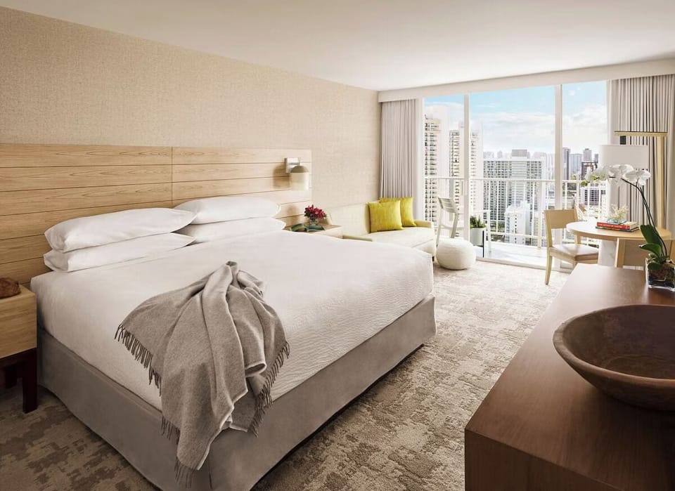 Unwind in airy comfort with skyline views and plush bedding.