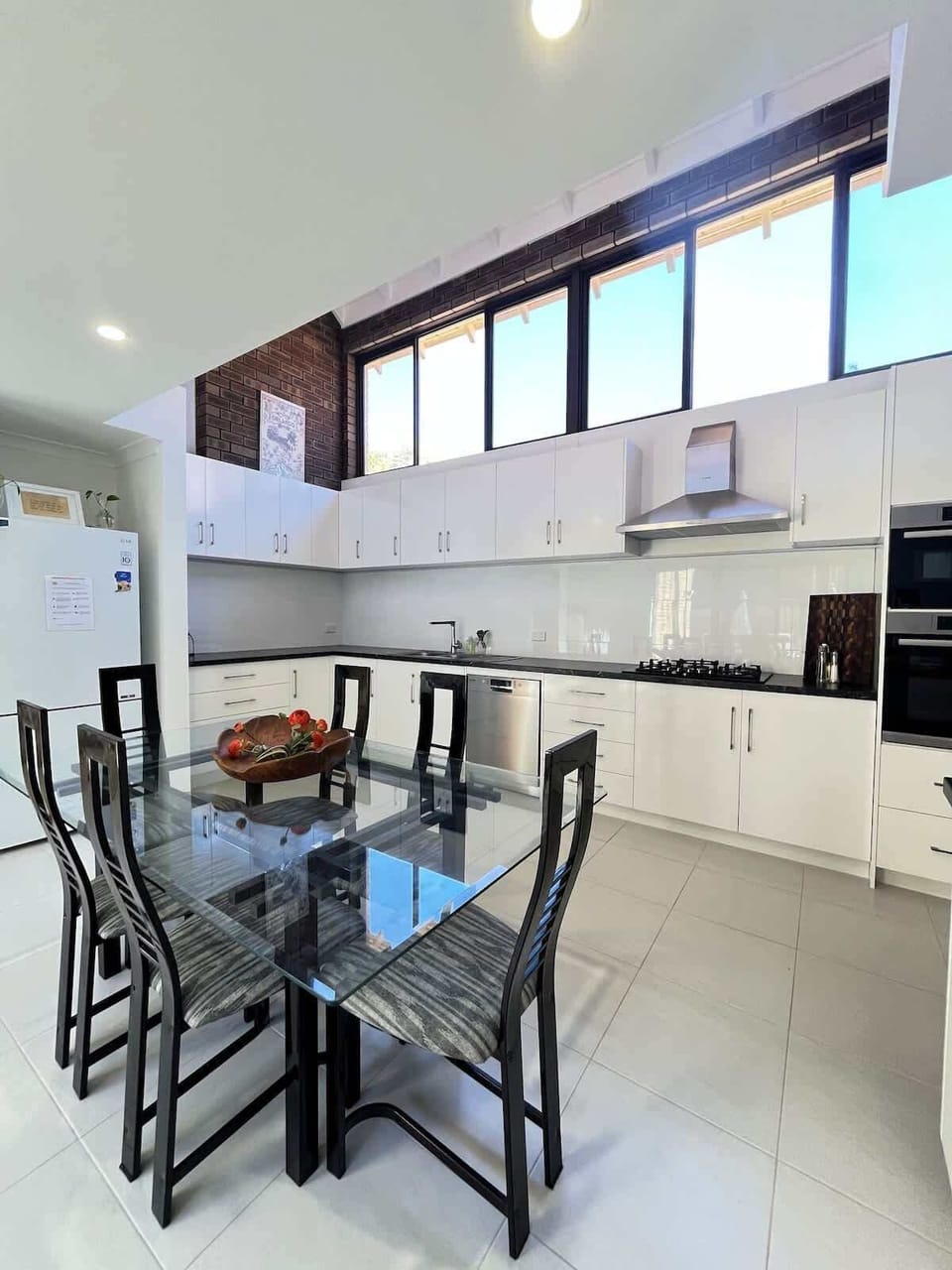Combined dining area and kitchen. The spacious dining table comfortably seats six, perfect for meals and gatherings. The bright kitchen boasts ample cabinets, a convenient sink, a refrigerator, and all the essential kitchen appliances.