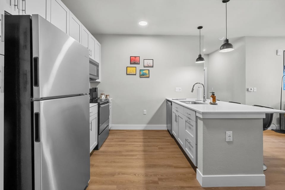 The fully equipped kitchen features sleek, modern appliances and ample counter space, making it easy to prepare your favorite meals or a simple cup of coffee!