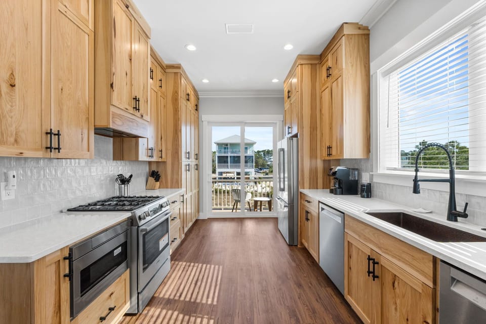 Cook with ease in your spacious galley kitchen featuring beautiful wood cabinets, granite countertops, and modern appliances - perfect for preparing meals during your stay.