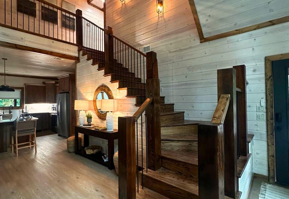 Wood accents and a beautifully designed staircase add a touch of rustic elegance to the home’s inviting layout.