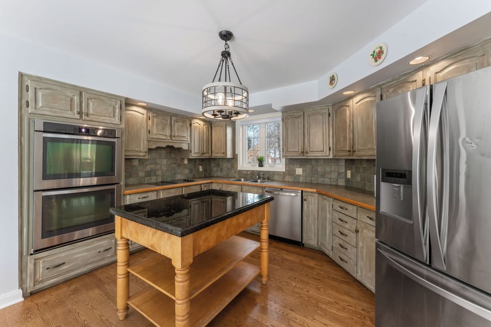 Stainless appliances modernize this rustic farmhouse-style kitchen