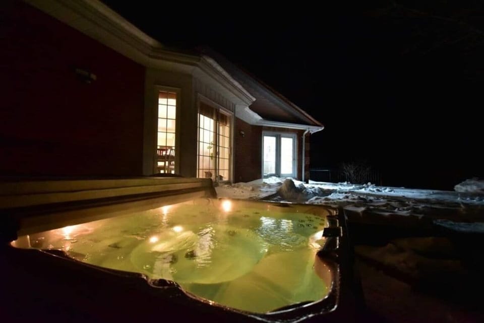 A glowing hot tub steams under the cold night sky.