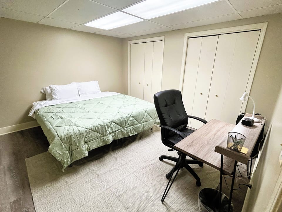 Room with a desk and two small closets, practical and cozy.