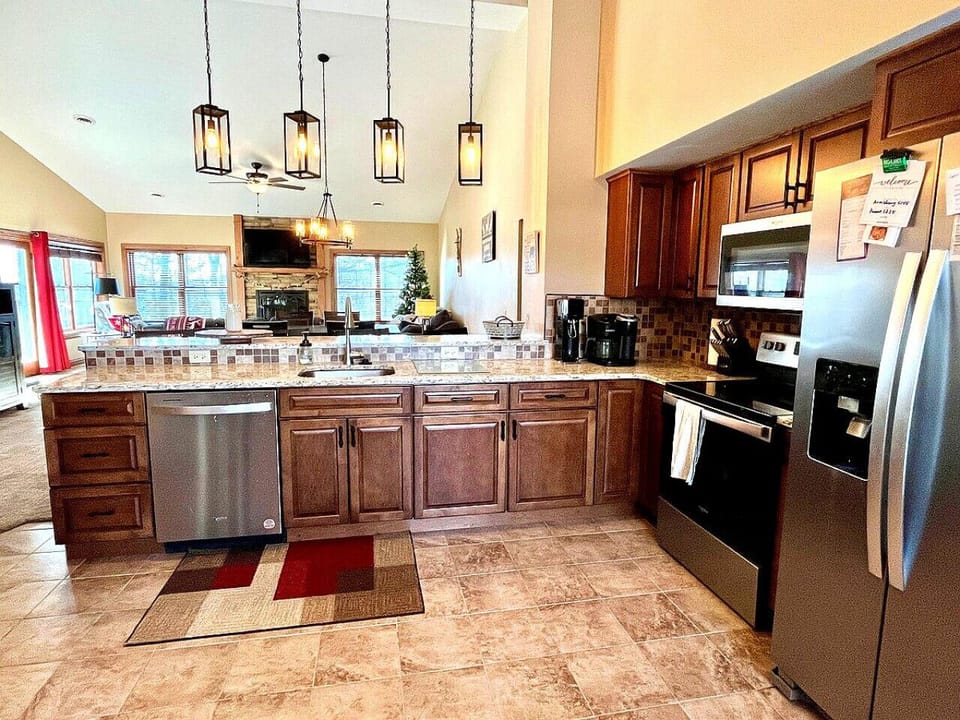 Bright & open designed kitchen with warm wood cabinetry, modern stainless steel appliances, and stylish lighting—perfect for cooking and entertaining