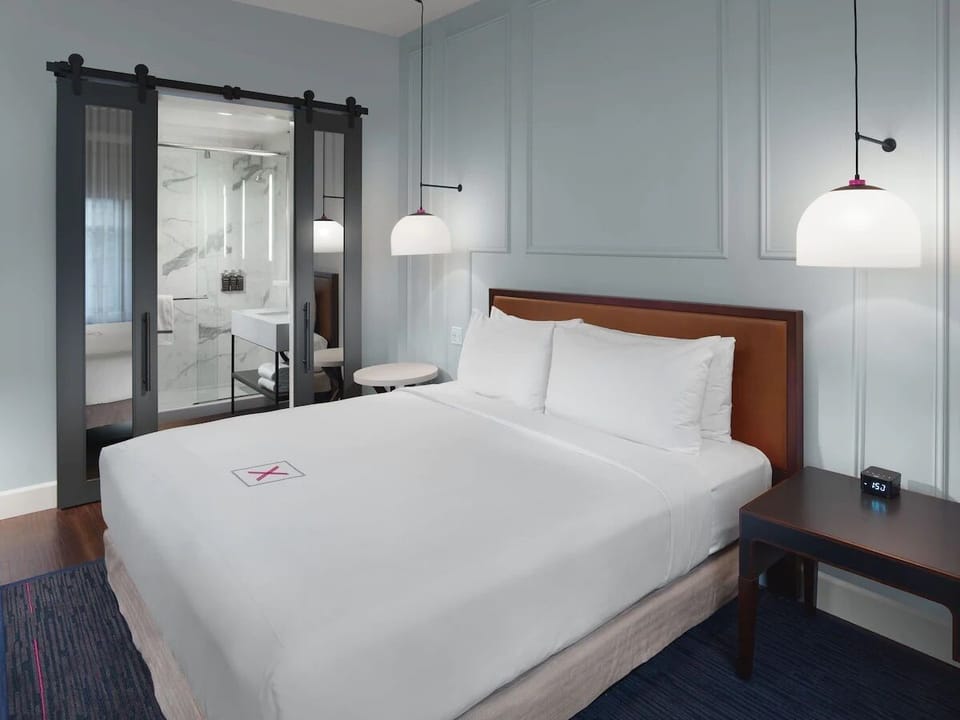 Unwind in crisp linens beside a sleek, spa-style ensuite.