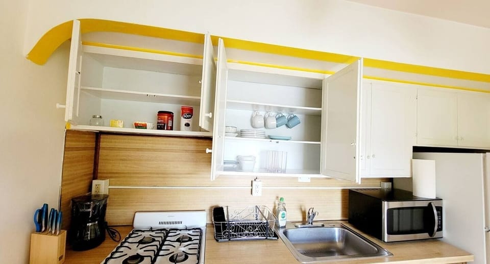 Step into a well-appointed kitchen designed for convenience. It includes a full-sized refrigerator, range, space for meal prep, and dining table. You'll find generous storage in the cabinetry, making it easy to keep things organized.
