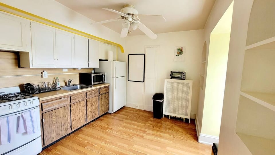 Step into a well-appointed kitchen designed for convenience. It includes a full-sized refrigerator, range, space for meal prep, and dining table. You'll find generous storage in the cabinetry, making it easy to keep things organized.
