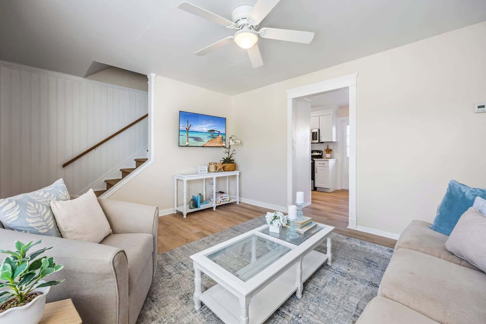 Bright living room with comfortable seating and a wall-mounted television.