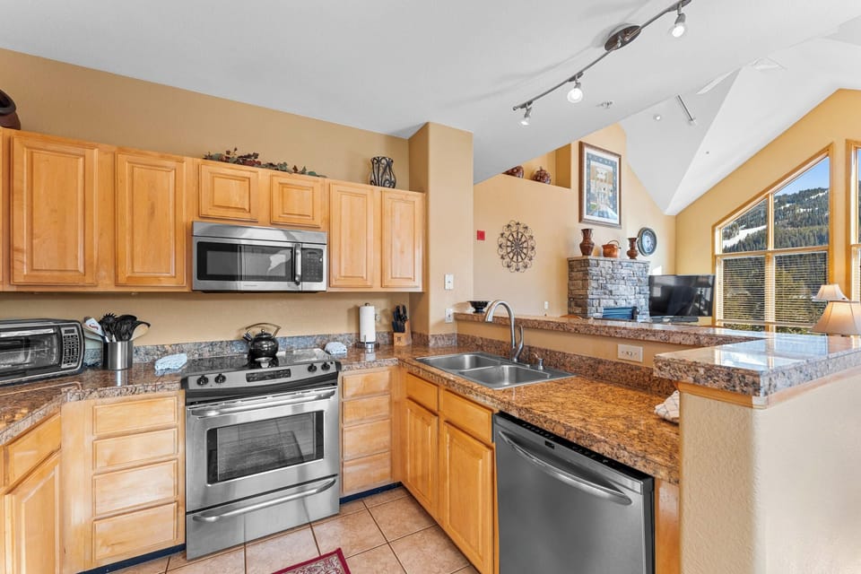 Full kitchen with stainless steel appliances, and breakfast bar seating 2 for casual dining.