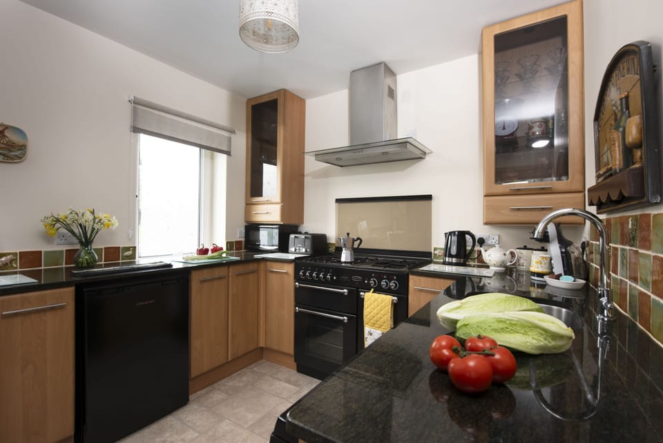 Honeycomb Cottage, Perranporth: Kitchen with an electric range oven, gas hob, fridge, freezer, microwave, dishwasher and coffee machine