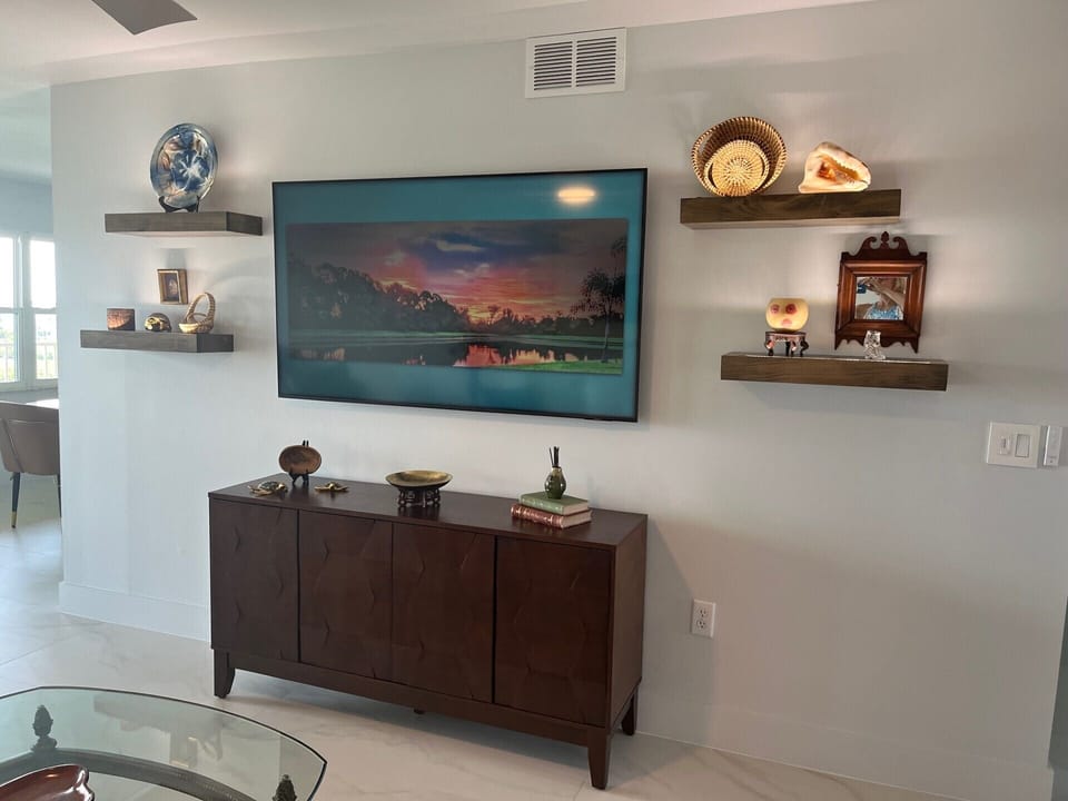 Living room with lighted floating shelves and 65" Smart TV