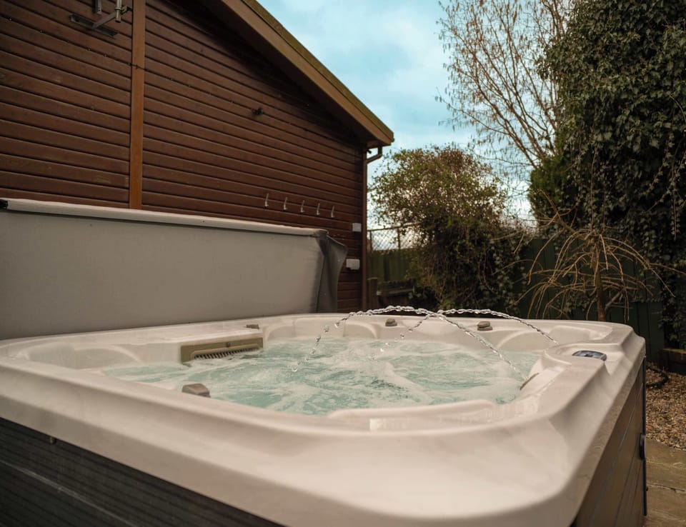 Unwind in the bubbling warmth of your private hot tub, perfectly placed for peace and privacy. The ultimate way to end your day in luxury and style.