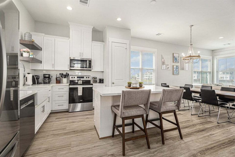 Modern open kitchen with large island, stainless steel appliances, and bar seating—perfect for entertaining in this Galveston vacation rental.