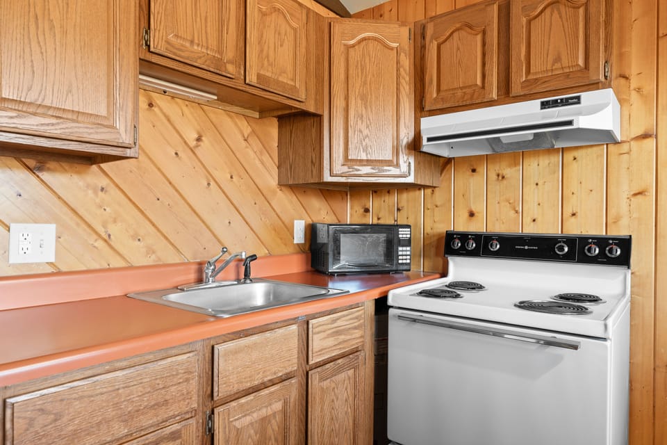 Fully equipped kitchen with rustic wood cabinetry, providing everything you need for a comfortable stay.