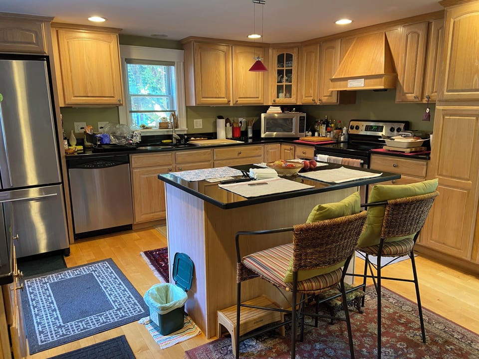 The full kitchen and island with two seats, a shared space