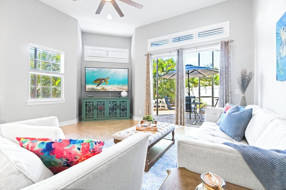 Lounge in a sun-filled space with cozy seating and direct access to the patio for indoor-outdoor comfort.