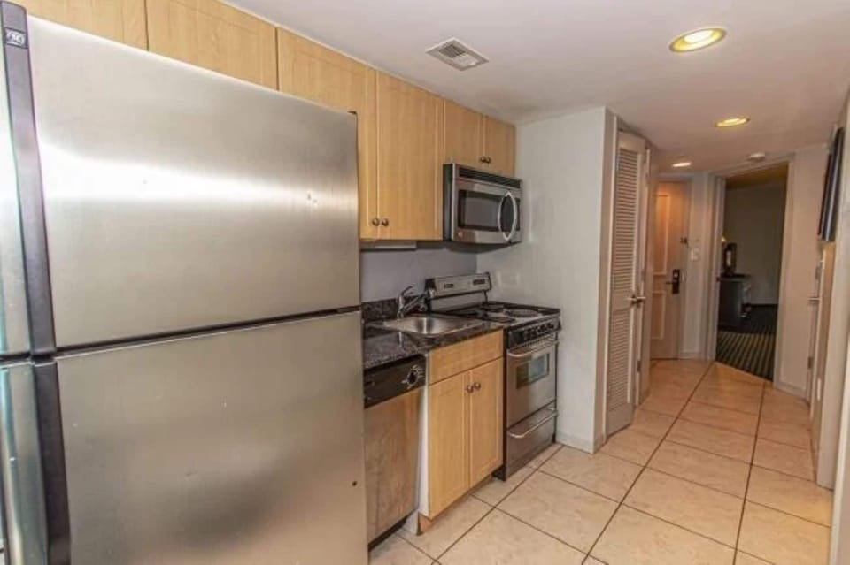 Modern kitchen with stainless steel fridge, stove, and microwave.