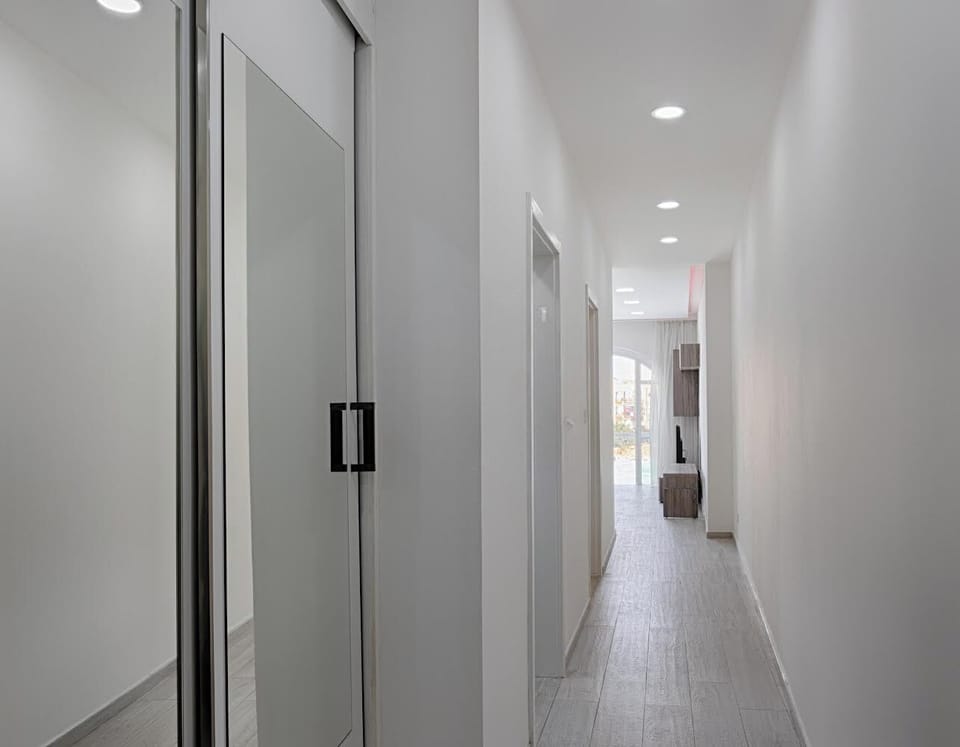 Corridor leading to bathroom, main bedroom and kitchen / living / dining area